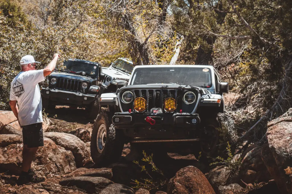 Summit 4X4 Jeep Wranglers navigating rocky off-road trail with trail guide
