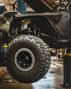 Summit 4X4 Jeep Wrangler lift kit installation with off-road tire upgrade in the shop