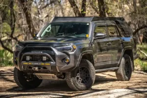Modified Toyota 4Runner TRD Pro with off-road upgrades parked on a forest trail.